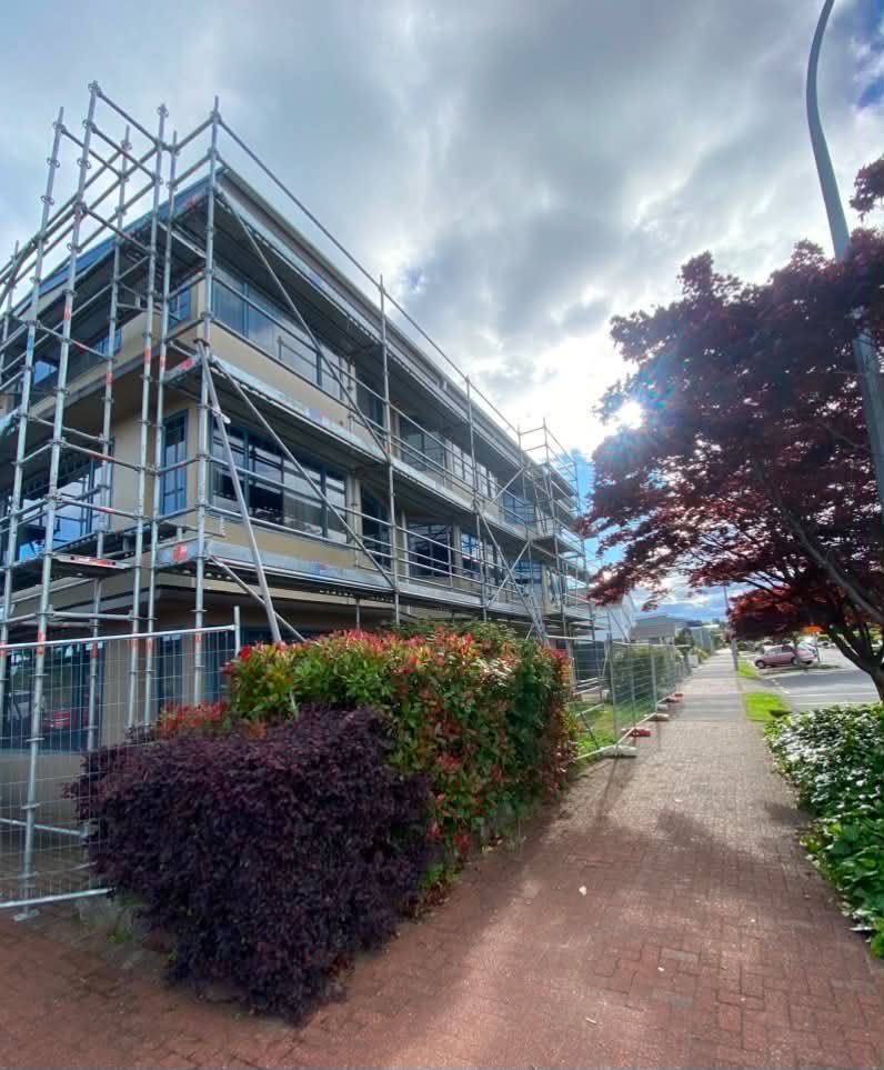 Street elevation of a three-storey commercial building with scaffolding across every level
