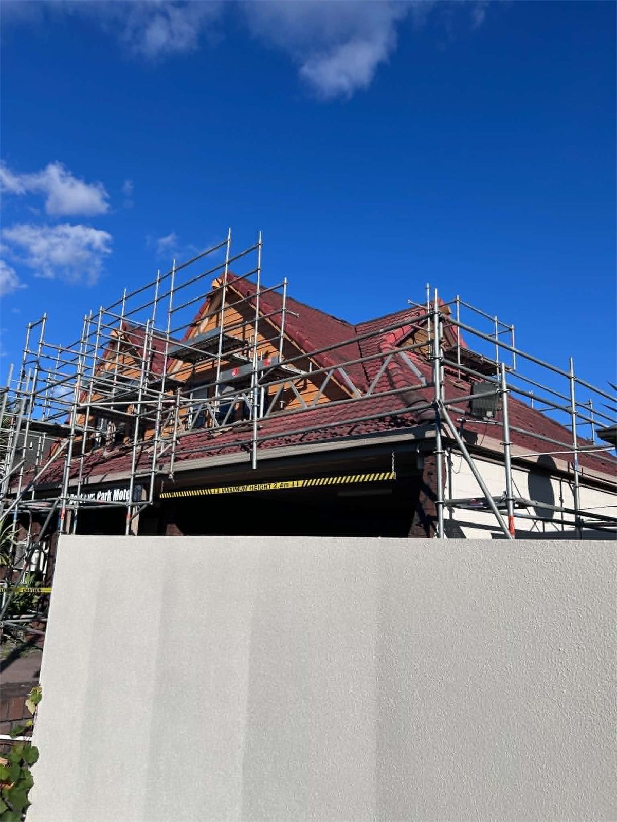 Scaffolding and edge protection running around the full perimeter of a tiled roof